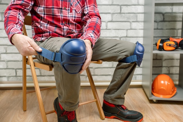 Worker wearing safety equipment a man wearing protective knee pads on the legs work safety protection equipment