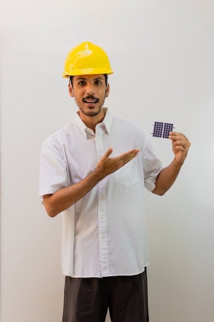 Worker with helmet holding a photovoltaic solar panel isolated on white background.