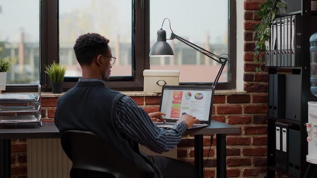 Worker with marketing experience planning financial investment, using laptop to create sales report. Company accountant working on finances and e commerce for digital development.