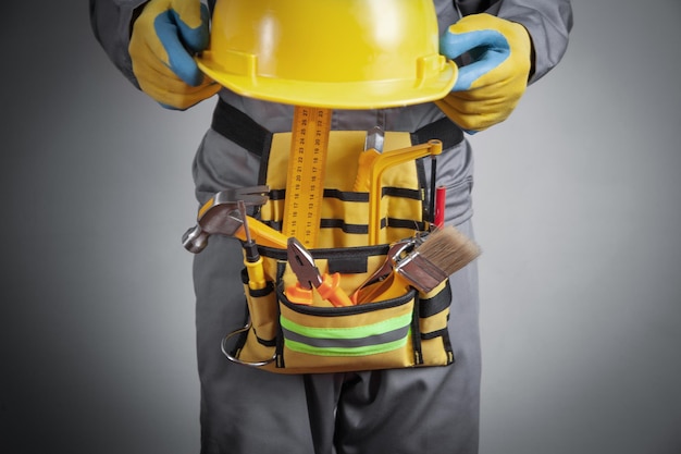 Worker with a tool belt and helmet Construction tools