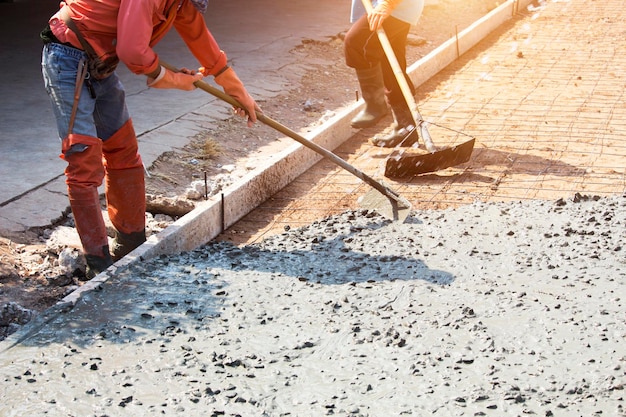 Workers are using tools to smooth the concrete floor