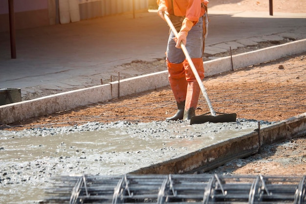 Workers are using tools to smooth the concrete floor