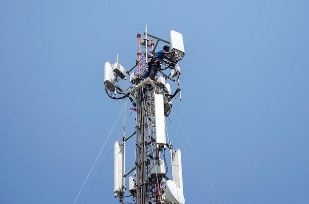 Workers are working at 5g antenna tower for maintainingserves cellular antenna technician worker