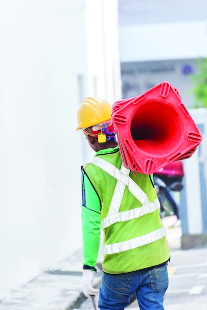 Workers carrying traffic cones.A road worker