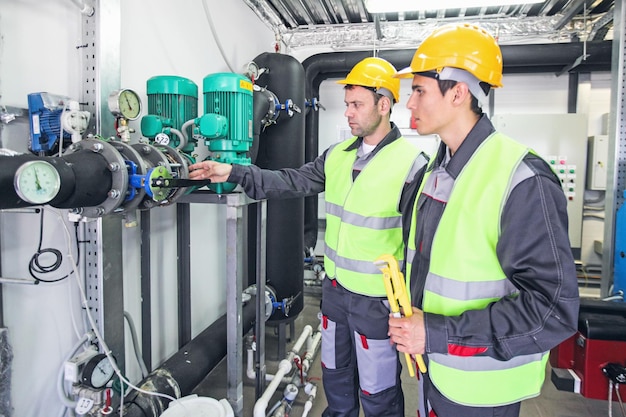 Workers check pipe monometer