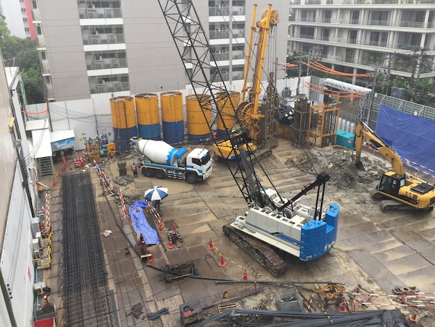 Workers in construction area with crane truck and holding machine