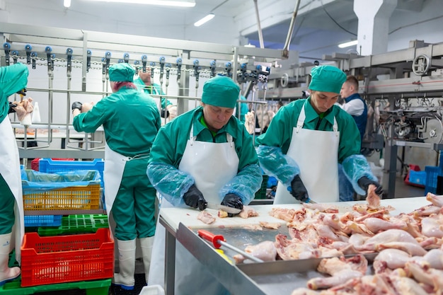 Workers in a factory with a large amount of meat on the table