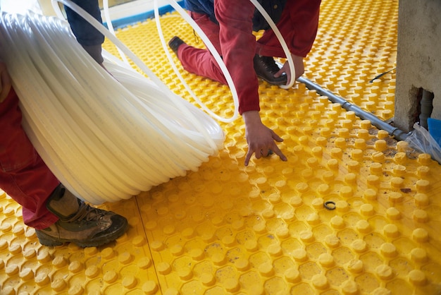 workers installing underfloor heating system