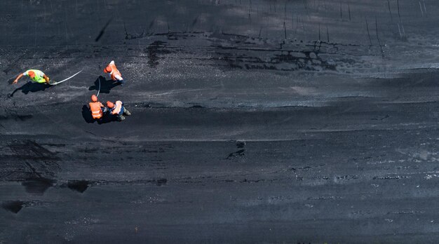 Workers lay new asphalt top view from the dron