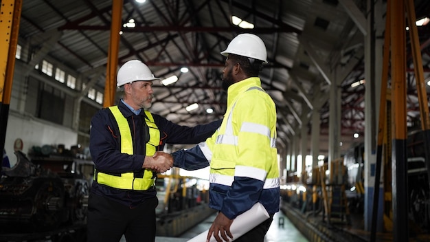 Workers meeting in engineering factory industry engineers shaking hand on business agreement