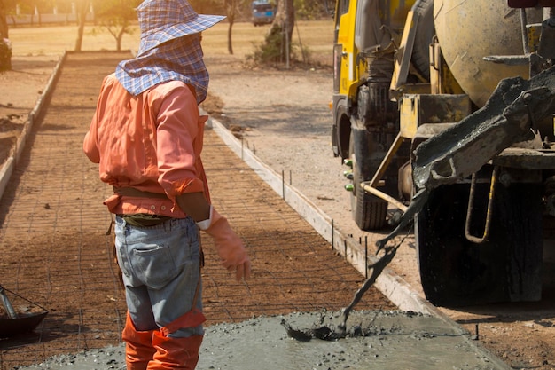 Workers pouring concrete with a cement mixer truck