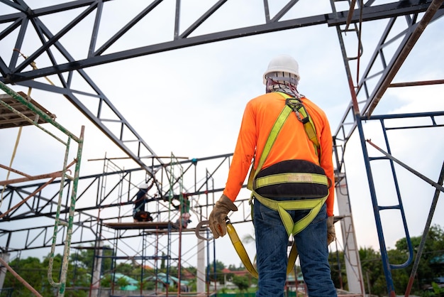 Workers prepare to go up with Fall arrestor device for worker with hooks for safety body harness on onstruction site