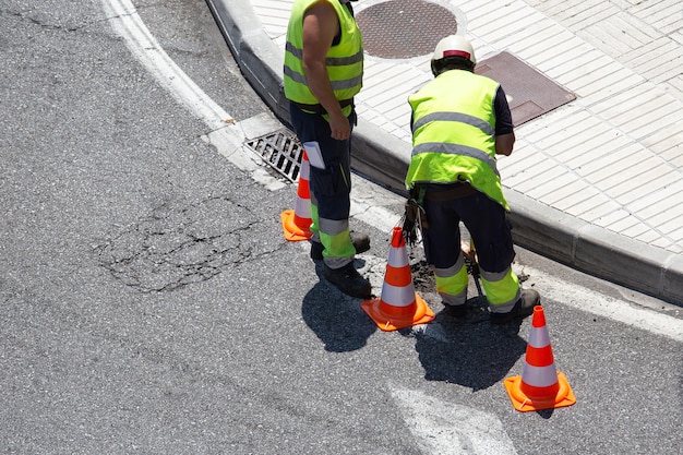 Workers repairing an asphalt road on city. Paving maintenance