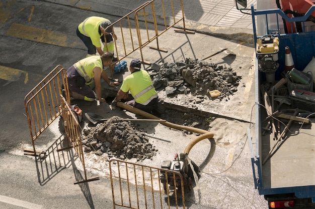 Workers repairing a broken water pipe on the road