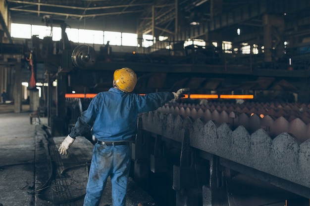 The workers at the steel works command the loading and unloading materials