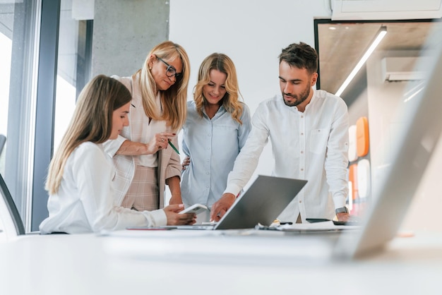 Working by laptop together Group of professional business people is in the office