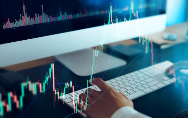 Working on a computer and graphing cryptocurrenciesfinance background