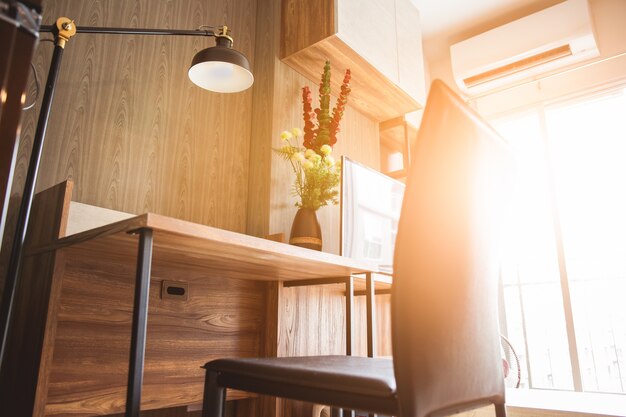 Working desk and chair with reading lamp in living room with shinning sunlight