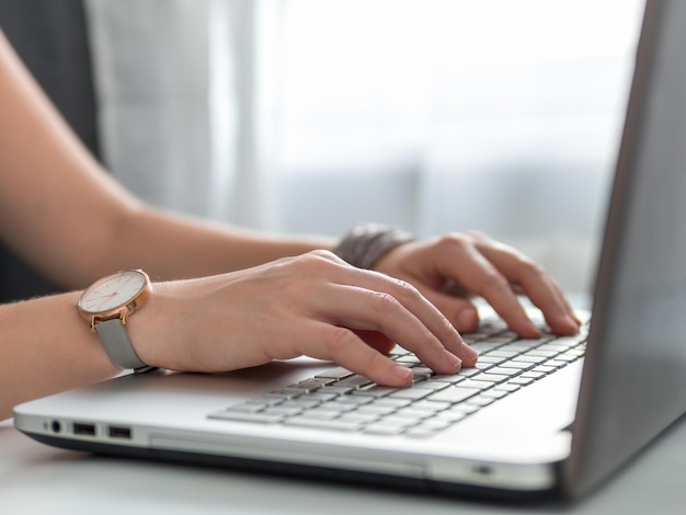 Working from home, contractor, freelance, social media, social marketing concept. Close-up woman's hands typing on laptop keyboard at home. Copy space for text or design