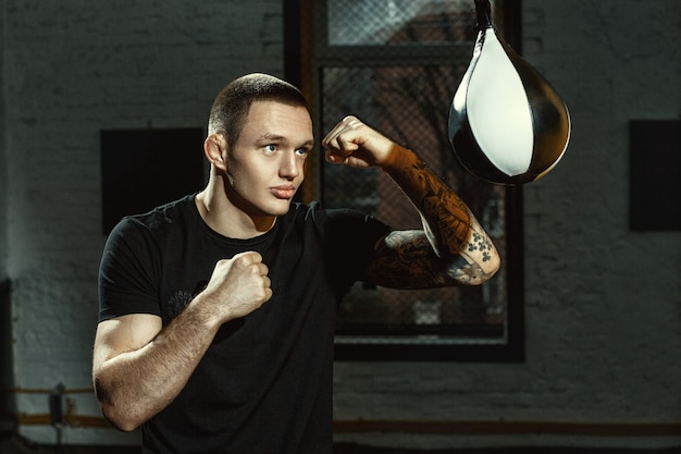 Working on his speed. Horizontal shot of a young male boxer practicing with the speed bag