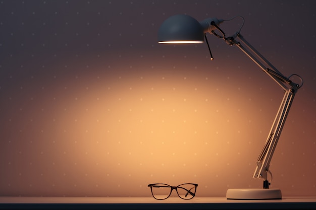 A working lamp shines at night on a table with glasses.