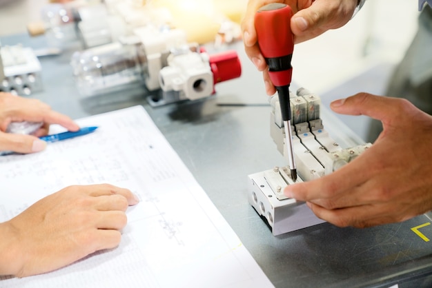 A working men hands using a screwdriver fix the pneumatic box.