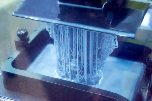 Photo working of photopolymer sla d printer platform with building object lowered into liquid photopolymer