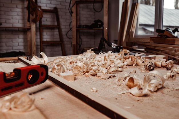 Working table with wood shavings in carpentry workshop