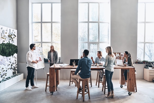 Working through some concepts. Two modern young men conducting a business presentation while standing in the board room