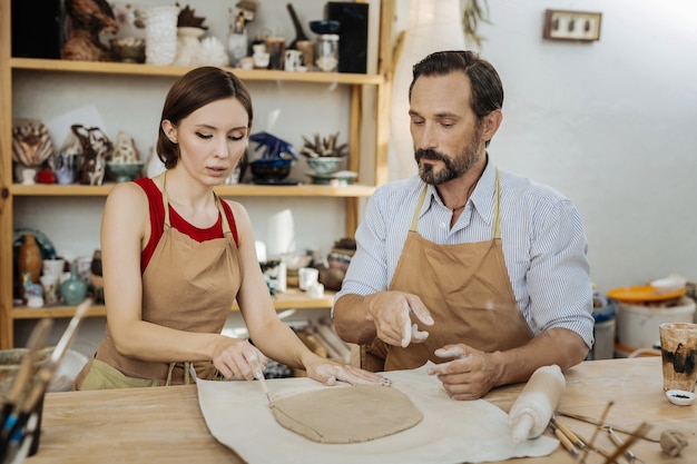 Working together. Couple of potters feeling amazing while working together in their modern spacious workroom