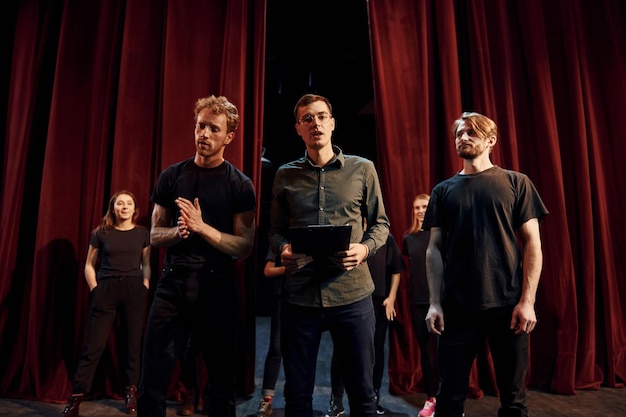 Working together Group of actors in dark colored clothes on rehearsal in the theater