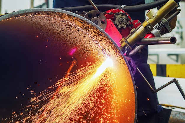 Working welder cuts metal and sparks fly Gas cutting of large diameter pipes with acetylene and oxygen Industrial metal cutting in oil and gas industry