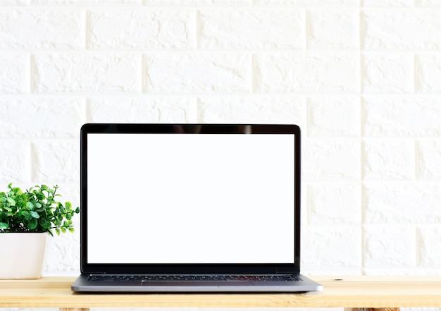 Working with Blank screen Laptop computer and plant copy space on wood desk background