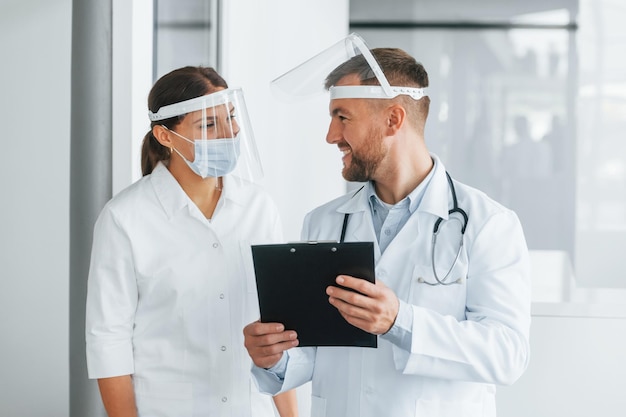 Working with documents Two doctors in white coats is in the clinic