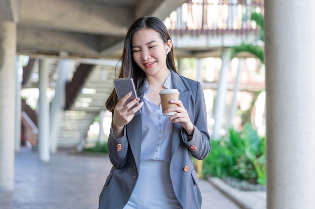 Working woman concept a young female manager holding a cup of coffee and communicating with the colleague via the video call.