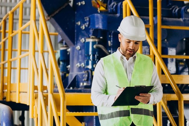 Workman in a factory writing notes