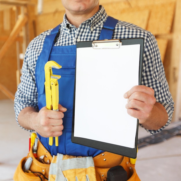 Workman with adjustable wrench and folder with blank document