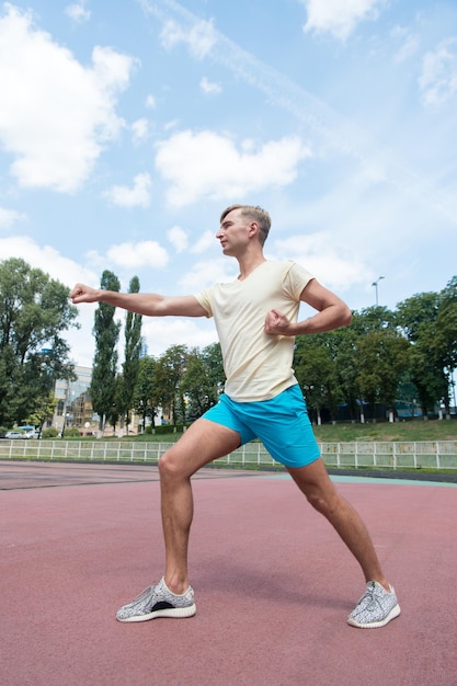 Workout of man punching sunny outdoor on blue sky sport and fitness