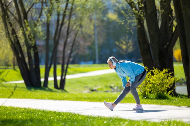 Workout Woman in blue blazer doing leanings in the park