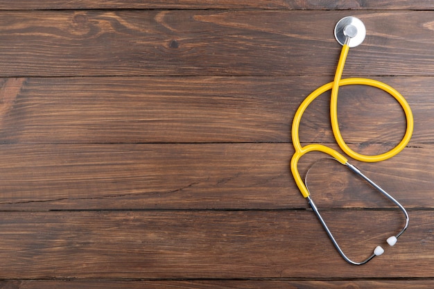 Workplace of a doctor Stethoscope and little heart on wooden desk background