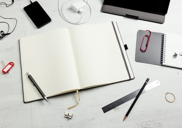 Workplace Empty notepad tablet pc and smart phone on white wooden table