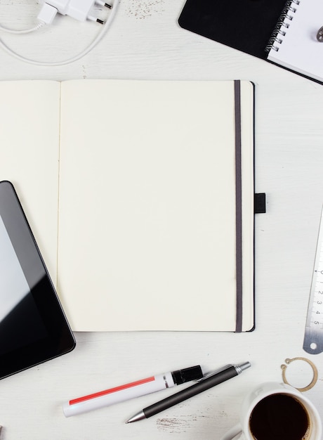 Workplace Empty notepad tablet pc and smart phone on white wooden table