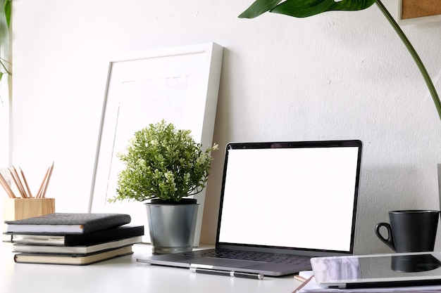 Workplace loft at home with laptop, mockup poster and supplies.