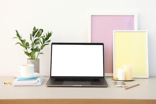 Workplace near the wall with a modern laptop