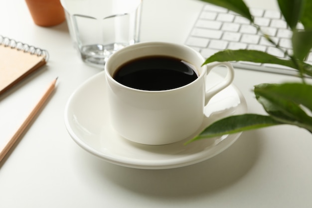 Workplace with cup of coffee on white