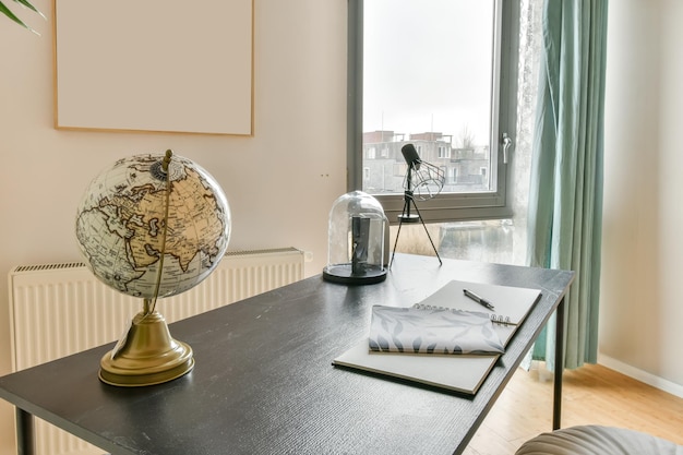 Workplace with a globe on the table next to the window and a view of the city