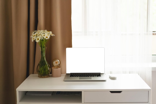 Workplace with laptop and home decor on the table against window View from front office table workplace at home