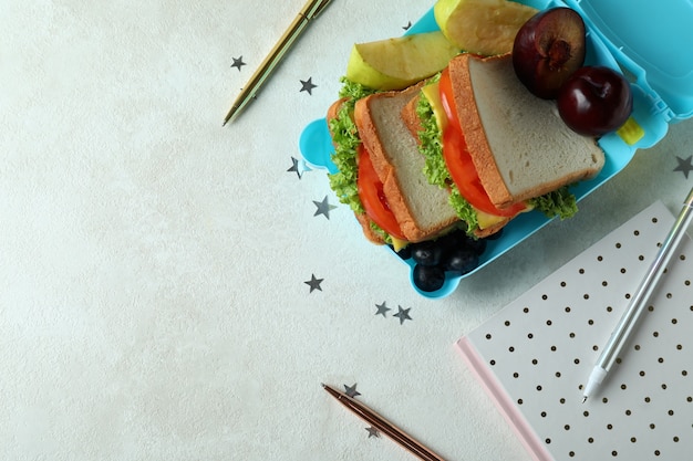 Workplace with lunch box on white textured table