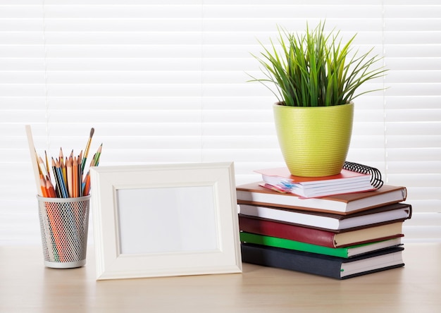 Workplace with photo frame pencils books