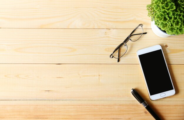 workspace desk with Smartphone and glasses and Pen.space for your text.